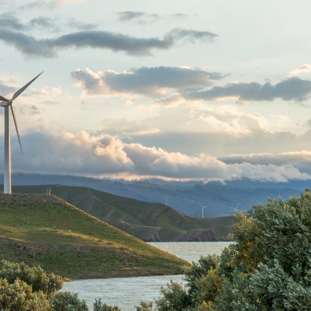 wind-power-turbine-hill-front-cloudy-sky